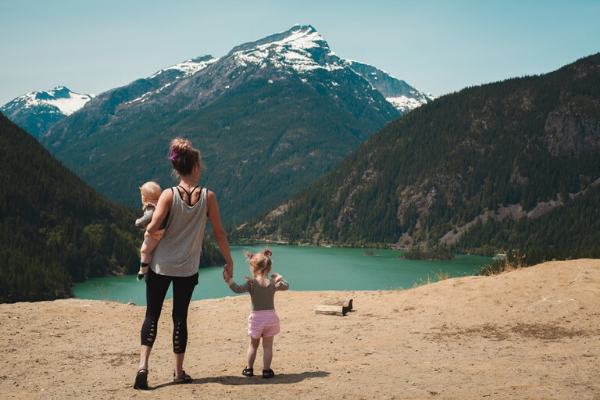 Travelling mother gazing at lake with toddler and baby. Photo by Josh Willink from Pexels