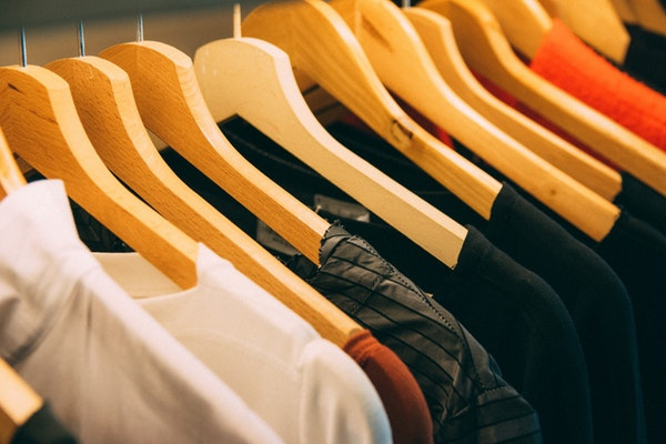 Close up of clothing rack with clothes on hangers. Photo by Kai Pilger from Pexels